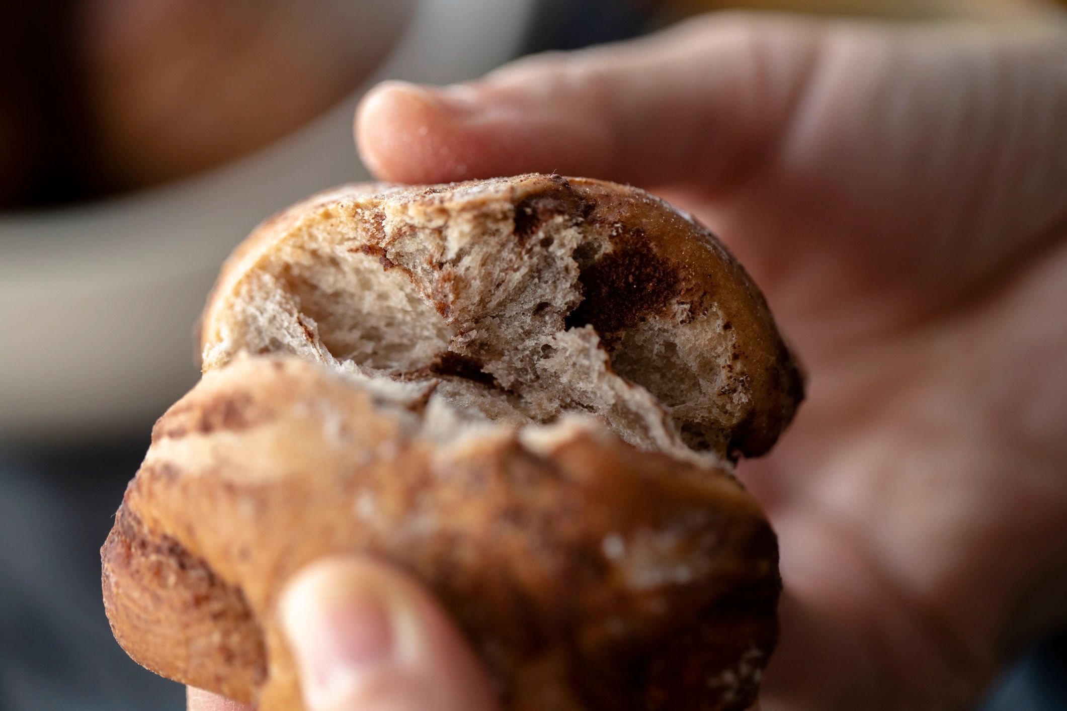 Hand holding a cinnamon roll
